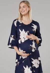 Navy floral maternity dress with short flared sleeves, featuring large white and beige flowers and a soft, stretchy fabric design.