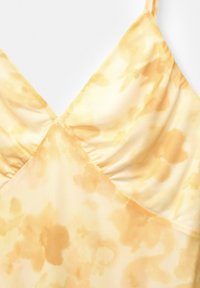 Gelb- und cremefarbenes Batik-Bralette aus weichem Stoff, mit V-Ausschnitt, gerafften Details und dünnen verstellbaren Trägern.