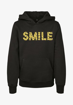 Sort hættetrøje med forlommer og ordet "SMILE" i gule bogstaver fyldt med mønstre af smilende ansigter.
