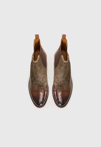 Botas de cuero marrón hasta el tobillo con parte superior texturizada en dorado y marrón, punteras afiladas, perforaciones decorativas y tiradores en el talón.