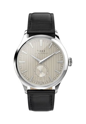 Часовник Timex Waterbury с кръгъл сребърен циферблат, тънки часови маркери, малък секунден подциферблат, корпус от неръждаема стомана и черна кожена каишка.