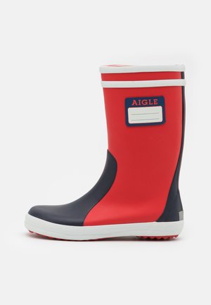 Rote und marineblaue Gummiregenstiefel mit einem weißen Streifen oben, einem Etikettenfeld und einer strukturierten Sohle für besseren Halt.