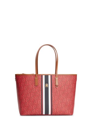 Red patterned tote bag with brown leather handles, central vertical black, white, and red stripes, and gold-tone logo emblem.