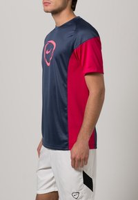 Lyhythihaine urheilupaita, navy ja vaaleanpunainen, kevyestä materiaalista, jossa on pyöreä pääntie ja logo keskellä.