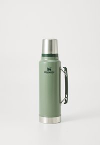 Green stainless steel thermos with textured finish, silver lid, and a sturdy handle. Features brand logo in dark green, cylindrical shape.