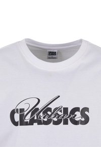 Balta medvilninė marškinėliai su apvaliu iškirpimu, papuošti išryškintu juodu tekstu "Urban Classics". Medžiaga atrodo lygi, o kirpimas laisvas.