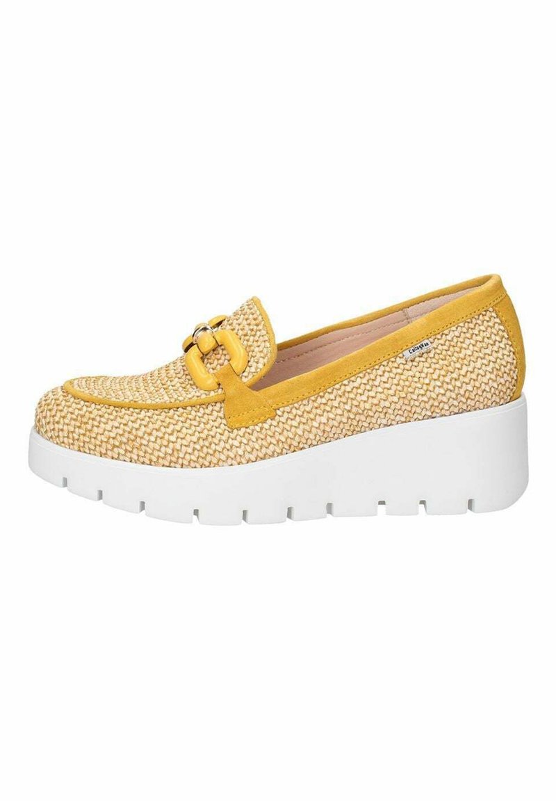 Scarpa slip-on intrecciata gialla e beige con una spessa suola piatta bianca, caratterizzata da una fibbia decorativa sul davanti e una superficie liscia.