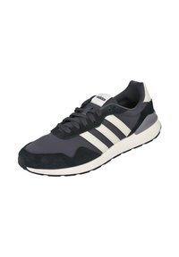 Zapatilla negra y gris con materiales de ante y textil, con tres rayas blancas, puntera redonda y suela de goma.