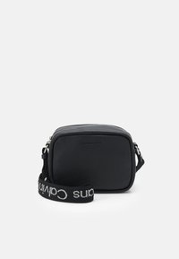 Borsa a tracolla nera con una texture sintetica liscia, forma rettangolare, chiusura con zip e una tracolla intrecciata con il logo "Calvin Klein".