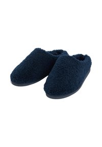 Une paire de chaussons en velours bleu marine, à enfiler, avec les orteils couverts et un tissu texturé doux, sur un fond blanc.