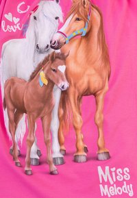 Il tessuto rosa presenta una grafica colorata di tre cavalli: un cavallo bianco, un cavallo marrone e un puledro con una macchia a forma di cuore. Sotto, la scritta "Miss Melody".