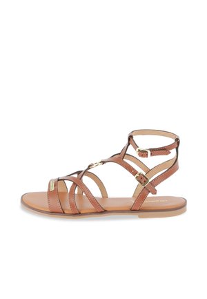 Sandalia plana de cuero marrón con múltiples tiras finas, dos hebillas ajustables en tono dorado y diseño de punta abierta sobre fondo blanco.