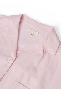 Lichtroze, linnen overhemd met korte mouwen, met een uitgesneden kraag, knoopsluiting en een klein zakje. Etiket vermeldt "STUDIO FEDER," maat "S."