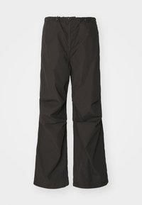 Pantalon noir ample avec une texture lisse. Ceinture élastique avec liens réglables et jambes droites. Pas de motifs ou d'accents visibles.