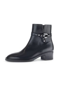 Bottine en cuir noir avec un bout rond, un talon bloc moyen, et une sangle sur le côté avec du matériel métallique et des accents à clous.