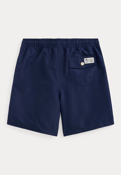 Short de bain bleu marine avec taille élastique, poche arrière à bouton unique avec petite étiquette blanche.
