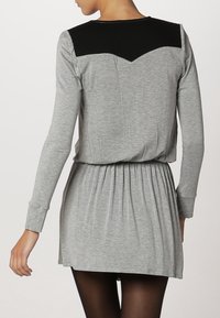 Robe grise à manches longues avec un empiècement structuré noir aux épaules, coupe décontractée, taille froncée et jupe évasée. Texture lisse.