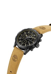 Montre chronographe noire avec cadran noir, accents jaunes et bracelet en cuir beige. Présente un design texturé et un logo gravé sur le bracelet.