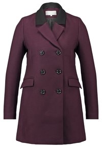 Dvojřadý kabát ve tmavě fialové látce s černým límcem, obsahující dvě přední kapsy a kulaté černé knoflíky pro zapínání.