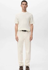 Béžové tričko s krátkým rukávem, světle béžové džíny, černý pásek a hnědé boty. Jednoduchý design, měkká textura a pohodlný střih.