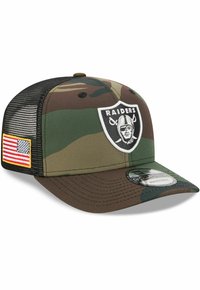 Tarnmuster-Baseballcap mit gebogenem Schirm. Ausgestattet mit einem Raiders-Logo auf der Vorderseite und einem Aufnäher der amerikanischen Flagge an der Seite. Mit Netzrücken.
