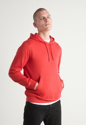 Sudadera con capucha roja hecha de un tejido suave, con un bolsillo frontal tipo canguro, capucha ajustable con cordón y puños y dobladillo acanalados.