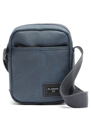 Small rectangular crossbody bag made of textured dark blue synthetic material. Features a front zip pocket and adjustable gray strap.