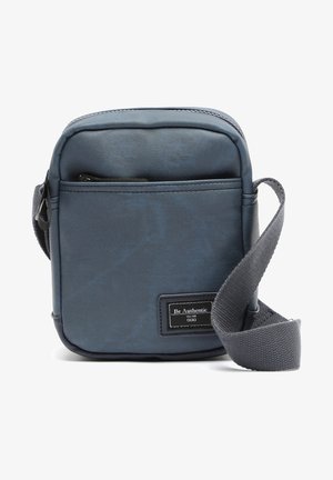 Liten rektangulär crossbody-väska i strukturerat mörkblått syntetmaterial. Har en framficka med dragkedja och en justerbar grå rem.