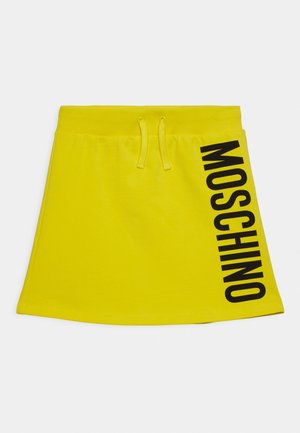 Heller gelber Rock mit elastischem Bund und Kordelzug, der auf der rechten Seite den auffälligen schwarzen vertikalen Schriftzug "MOSCHINO" trägt.