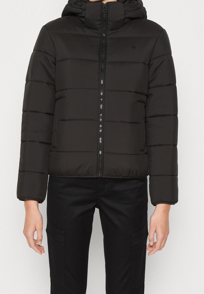 Doudoune noire avec capuche, dotée de surpiqûres horizontales, d'une fermeture éclair à l'avant et de poignets élastiques. Fini mat avec un logo étroit sur la poitrine.
