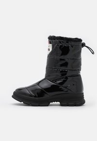 Botte d'hiver noire imperméable avec tige en synthétique, design matelassé, doublure en fausse fourrure, cordon élastique en haut et semelle en caoutchouc épaisse.