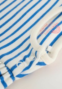 Un body pour bébé rayé bleu et blanc avec des boutons-pression et un bord crème autour du col sur un fond clair.