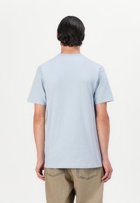 Lys blå bomulls-t-skjorte med rund hals og korte ermer. Enkel design, myk tekstur, uten synlige mønstre eller detaljer.