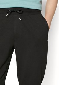 Svarta sweatpants i mjukt material, med elastisk midja och dragsko samt sidofickor.
