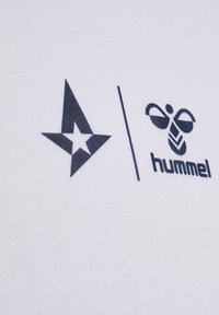 Hvidt stof med sorte trykte logoer: en stjerne til venstre og et bi-design til højre, adskilt af en lodret linje.
