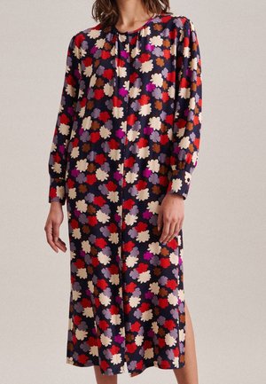 Kukkamalli midi mekko, jossa on pitkät puff-hihat, tummansininen tausta ja monivärisiä kukkakuvioita punaisena, vaaleanpunaista, kermaista ja ruskeaa. Keskisaumayksityiskohta.