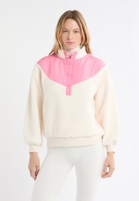 Pullover in pile crema con pannello in nylon rosa sul collo e sulle spalle, con chiusura a mezza abbottonatura e fascia a coste in vita, maniche lunghe.