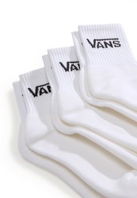 Vita bomullssockor staplade, med ribbade kanter och en svart "VANS"-logotyp på varje socka. Mjuk textur och standard crew-längd.