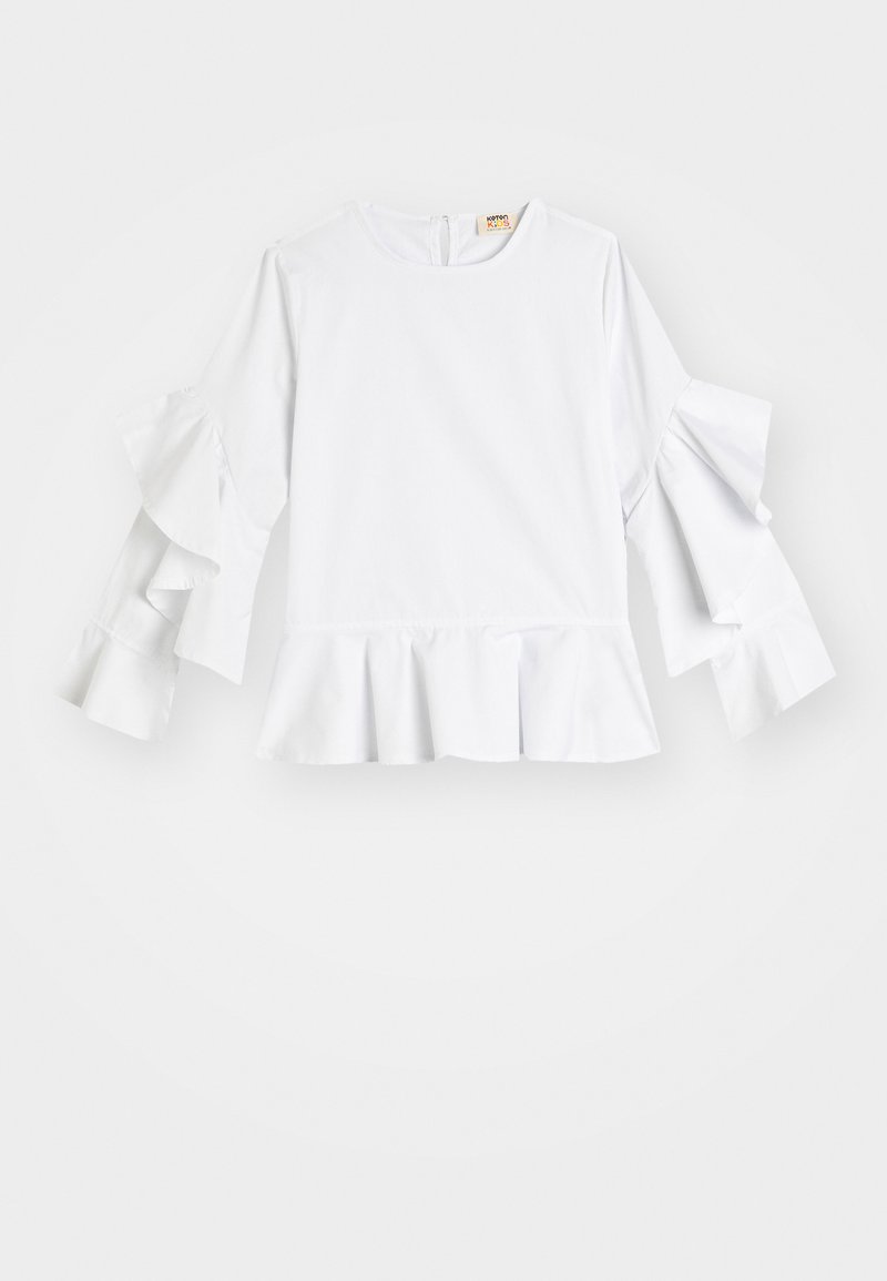 Hvid langærmet top med flæser på ærmerne og kanten; har rund udskæring og lynlås i ryggen; lavet af glat stof.