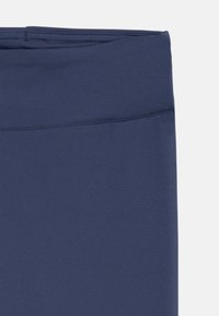 Marineblauwe leggings met een gladde, rekbare textuur. Beschikt over een brede tailleband en een naadloos ontwerp, geschikt voor sportkleding.
