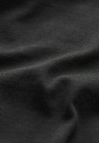 Tessuto nero con una superficie liscia e leggermente testa di marmo, caratterizzato da morbide pieghe e sottili variazioni di tonalità.
