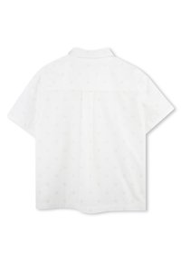 Chemise blanche à manches courtes avec un motif subtil, col boutonné et un pli dans le dos pour plus de confort. Texture lisse, design épuré.
