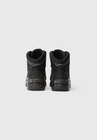 Zwarte high-top schoenen met een soepele suede en mesh-textuur, voorzien van een ronde neus, gevoerde kraag en rubbere zool. Reflecterende accenten zijn aanwezig.