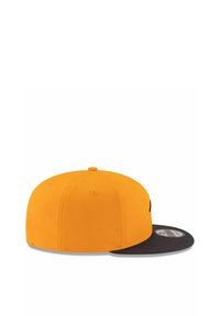 Gelbe Kappe mit einem flachen schwarzen Schirm, aus glattem Stoff gefertigt. Verfügt über genähte Belüftungslöcher und einen größenverstellbaren Snapback-Verschluss.