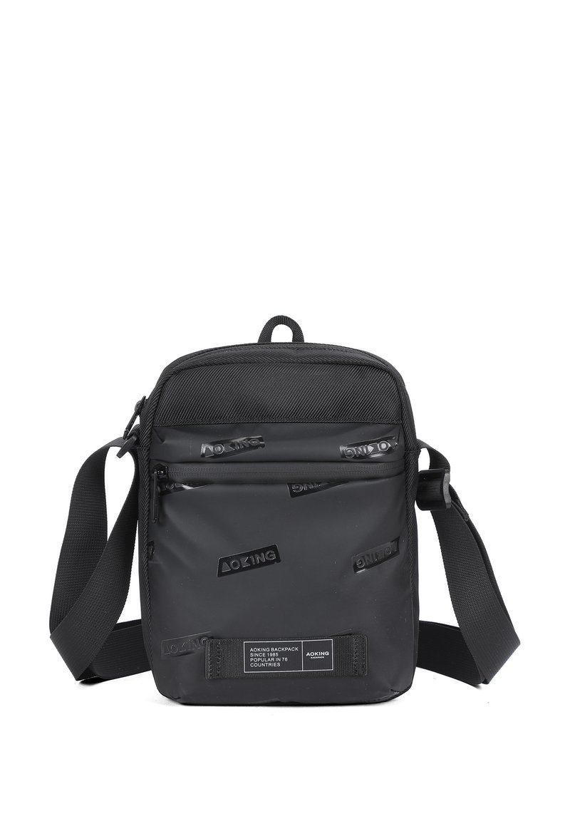 Borsa a tracolla nera realizzata in materiale resistente, con un pannello frontale testurizzato e loghi in rilievo, tracolla regolabile e scomparti con zip.