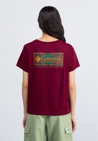 Bordeaux värvi puuvillane T-särk lühikeste varrukatega. Seljaosal on värvikas Columbia Sportswear Company logo ristkülikukujulises disainis.