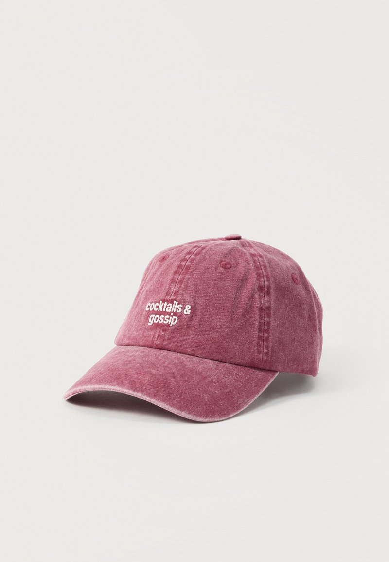 Casquette de baseball violette délavée avec texte brodé blanc "cocktails & gossip" à l'avant, présentée sur un fond blanc uni.
