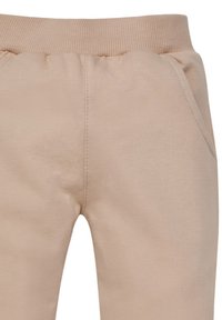 Beige Sweatpants mit elastischem Bund, ausgestattet mit Seitentaschen und einer glatten Baumwolltextur. Einfaches Design ohne sichtbare Muster.