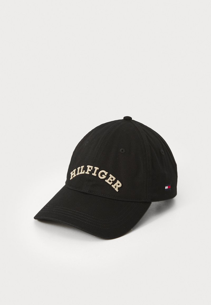 Sort baseball cap lavet af stof med en buet skygge og broderet "HILFIGER" i guld. Har et lille logo-tag på siden.