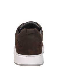 Bruine suede sneaker met een witte rubberen zool. Kenmerken zijn een low-top ontwerp, een gevoerde kraag en een getextureerde achterzijde voor grip.